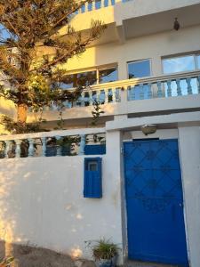 a house with a blue door in front of it at Happy Waves Morocco in Taghazout