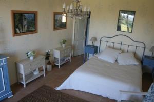 a bedroom with a bed and a chandelier at La Rolandie Haute in Limeuil