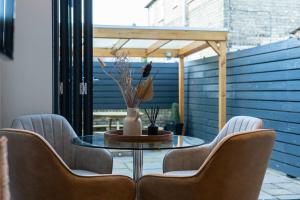 a dining room with chairs and a table with a vase at Beautiful 2 Bedroom Home in Cambridge