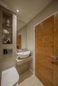 a bathroom with a sink and a toilet and a door at Beautiful 2 Bedroom Home in Cambridge +13 photos