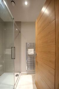 a bathroom with a shower and a wooden door at Beautiful 2 Bedroom Home in Cambridge