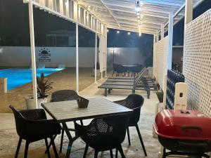 a patio with a table and chairs and a pool at Beachtown Luxury Villas Apt 101 in Aguadilla
