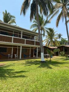 Un edificio con palmeras delante. en Cabañas Edda, en Puerto Escondido