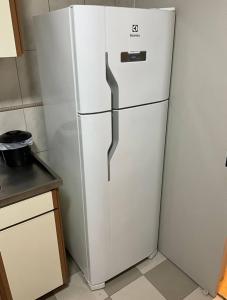 a white refrigerator in a kitchen next to a counter at Ape Av Brasil pertinho do mar in Balneário Camboriú