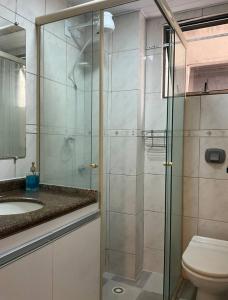 a bathroom with a glass shower and a toilet at Ape Av Brasil pertinho do mar in Balneário Camboriú