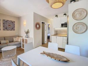 Una cocina y una sala de estar con una mesa y sillas blancas. en Can Alfredo, Apartamento Cala en Bosch con piscina, terraza y jardín privado, en Cala'n Bosch