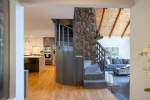 a living room and kitchen with a stone wall at Kenwood Vista by AvantStay 7acres w Pool Fire Pit Vineyard Views in Kenwood