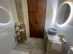 a bathroom with a sink and a wooden door at Dream Big with jacuzzi and terrace in Ruzafa in Valencia +52 photos