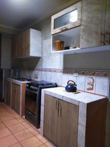 a kitchen with a stove and a tea kettle on the counter at Alojamiento Místico in Ayacucho
