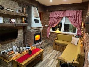 a living room with a couch and a fireplace at Matanovi Dvori in Slavonski Brod