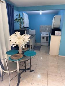 a kitchen with a table and two chairs with flowers on it at Chelsea Bliss in Kingston +3 photos