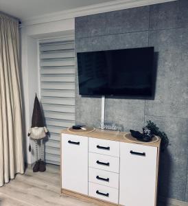 レンボルクにあるMarzecz HOME Lębork Centrumのリビングルーム(ドレッサーの上にテレビ付)