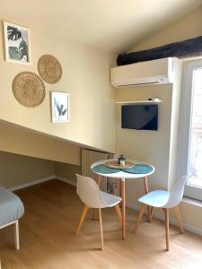 a living room with a table and chairs and a tv at Casa Nina in Turin
