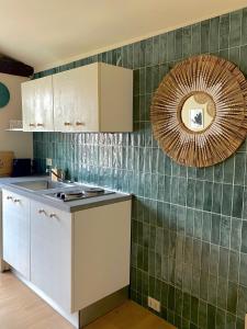 a kitchen with green tiles on the wall and a mirror at Casa Nina in Turin