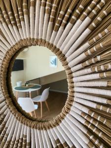 a circular mirror reflecting a room with a table at Casa Nina in Turin