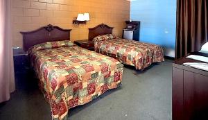 a hotel room with two beds and a desk at Economy Hotel Dublin in East Dublin