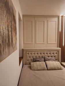 Apartman MagicD في ديفشيبار: غرفة نوم بها سرير ولوحة على الحائط