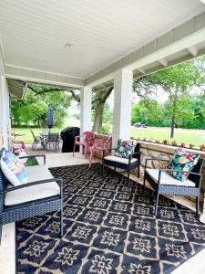 eine Veranda mit Stühlen und Tischen und einem Teppich in der Unterkunft Lake Life Lodge Cottage by Belton Lake in Belton