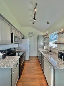 a kitchen with stainless steel appliances and a white refrigerator at Pecan Place Rustic Charm Temple Texas in Temple