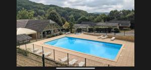 an overhead view of a swimming pool in front of a house at Chalet climatisé dans un écrin de verdure in Lissac-sur-Couze