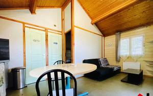 a room with a table and chairs and a couch at Chalet climatisé dans un écrin de verdure in Lissac-sur-Couze