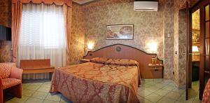 a hotel room with a bed and a chair at Hotel Nespolo D'Oro in Lariano