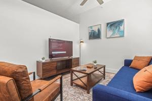 a living room with a blue couch and a tv at Pampering New Unit Studio 1Ba Pool, Golf Sim in Austin