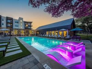 a swimming pool with purple lights in a building at Pampering New Unit Studio 1Ba Pool, Golf Sim in Austin