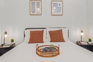 a bedroom with a white bed with a basket on it at Pampering New Unit Studio 1Ba Pool, Golf Sim in Austin +17 photos
