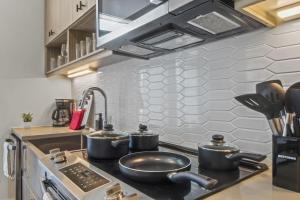 a kitchen with three pots on a stove at Pampering New Unit Studio 1Ba Pool, Golf Sim in Austin