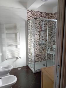 a bathroom with a glass shower and two toilets at Casa Gioia in Persano