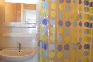 a bathroom with a sink and a shower curtain with polka dots at SP230-005 Studio 2 couchages SAINT PIERRE LA MER in Saint Pierre La Mer