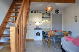 a kitchen and dining room with a staircase in a house at SP190-119 Maison mezzanine 6 couchages SAINT PIERRE LA MER in Saint Pierre La Mer