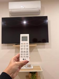 a person holding a remote control in front of a tv at Appartement cosy à Liège in Liège