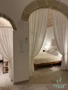 Schlafzimmer mit einem Bett mit weißen Vorhängen in der Unterkunft EL-MAR housea exclusive terrace, sea view in Polignano a Mare + 60 Fotos