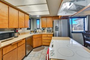 a kitchen with wooden cabinets and a stainless steel refrigerator at 3 Mi to The Polar Express Williams Home with Grill! in Williams