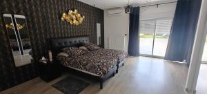 a bedroom with a bed and blue curtains and a chandelier at Villa T5 proche centre ville in Aix-les-Bains