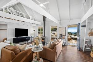 a living room with two couches and a fireplace at Honey Hill in Glenlyon