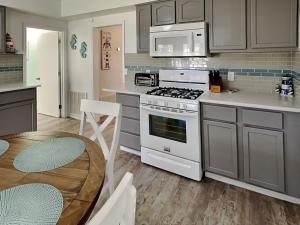 a kitchen with a white stove and a table at The Charming Cozy Cottage in Rockport +13 photos