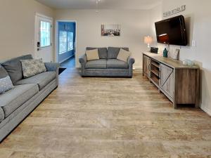 a living room with a couch and a flat screen tv at The Charming Cozy Cottage in Rockport