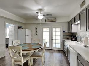 a kitchen with a table and chairs and a refrigerator at The Charming Cozy Cottage in Rockport
