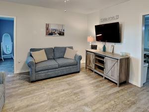 a living room with a couch and a flat screen tv at The Charming Cozy Cottage in Rockport