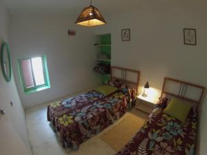 a small bedroom with two beds and a lamp at El Vuelo de la Libélula in Barbate