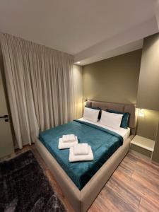 a bedroom with a bed with two towels on it at Liams Cozy Villa in Korçë