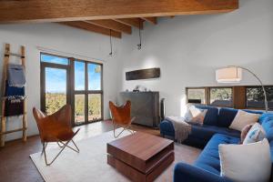 a living room with a blue couch and chairs at Casa de Flechas in Santa Fe NM in Santa Fe