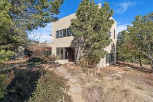 an exterior view of a white house with trees at Casa de Flechas in Santa Fe NM in Santa Fe