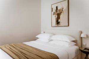 a bedroom with a white bed with white pillows at Likno Athens in Athens