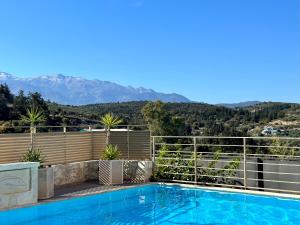 a villa with a swimming pool with mountains in the background at Aegean View Villa, 2-min Drive to Almyrida Beach in Almyrida