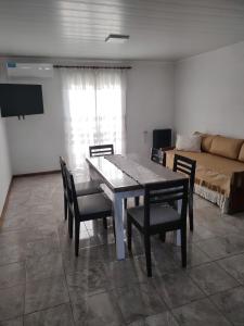 ein Esszimmer mit Tisch und Stühlen und einer Couch in der Unterkunft Lodge Araucaria Apartamento por día in Eduardo Castex