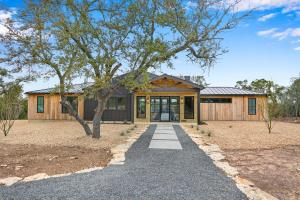 una casa con un albero e una passerella di Pasatiempos a Wimberley
